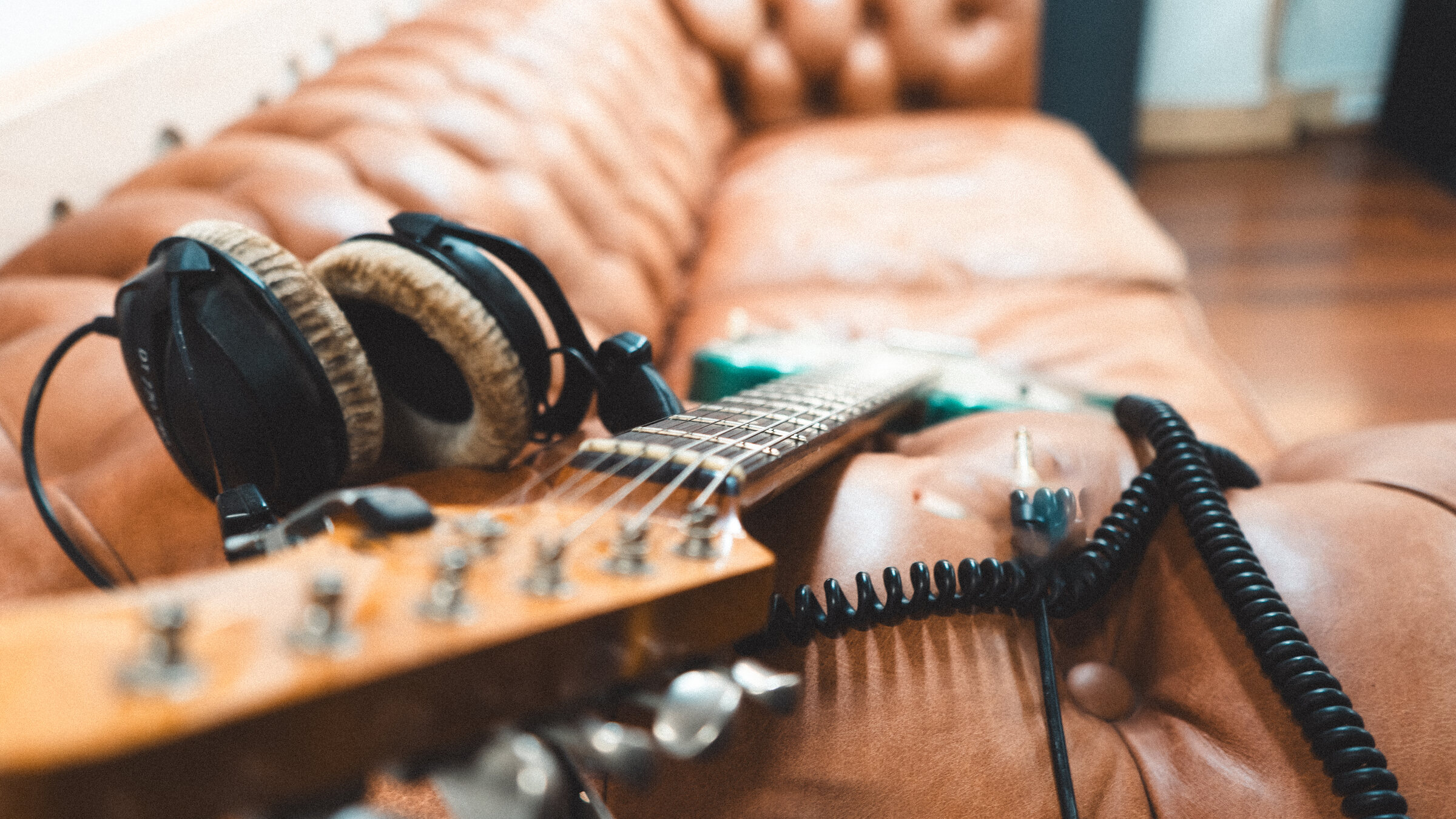 E-Gitarre mit Kopfhörern auf einer Ledercouch im Sound Oak Studio